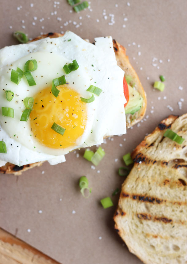 Breakfast Sandwich with Avocado, Tomato, Feta Cheese and a Fried Egg on Toasted Sourdough