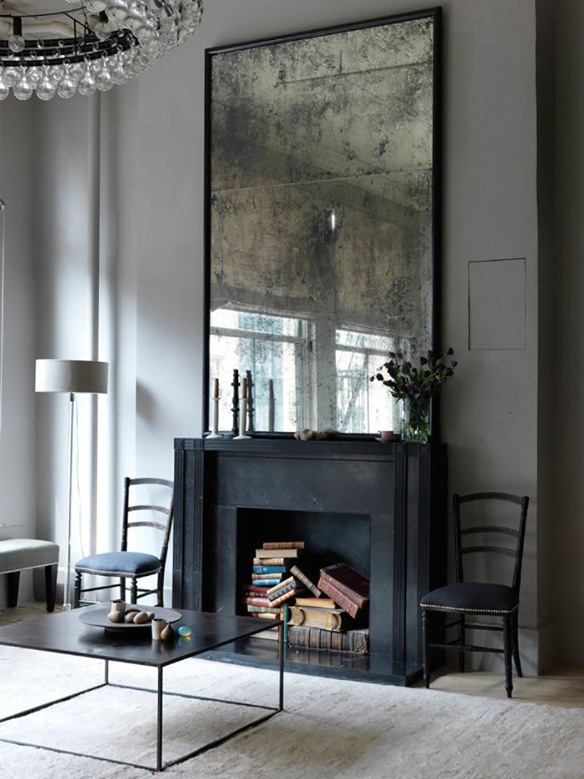 oxidized mirror over black fireplace