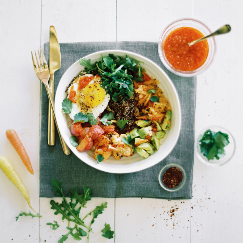 Quinoa bowl with harissa-roasted veggies, avocado, and fried egg