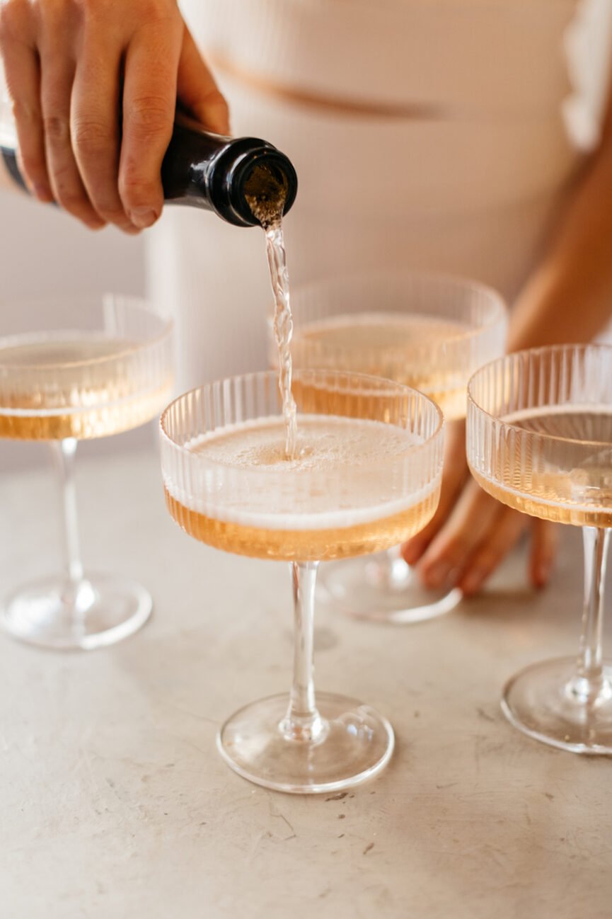 Pouring champagne into coupe glasses