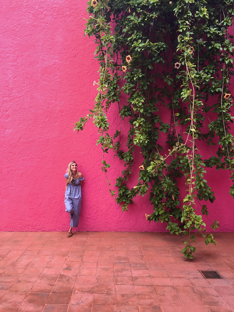 Claire Zinnecker in front of magenta wall at CASA LUIS BARRAGÁN in Mexico City.
