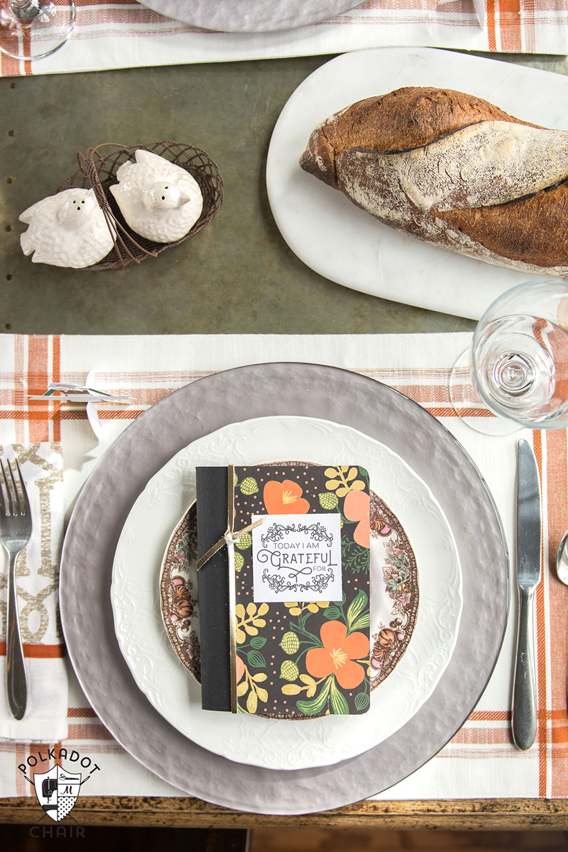 Set each place setting with a gratitude journal and pen guests can take home with them.