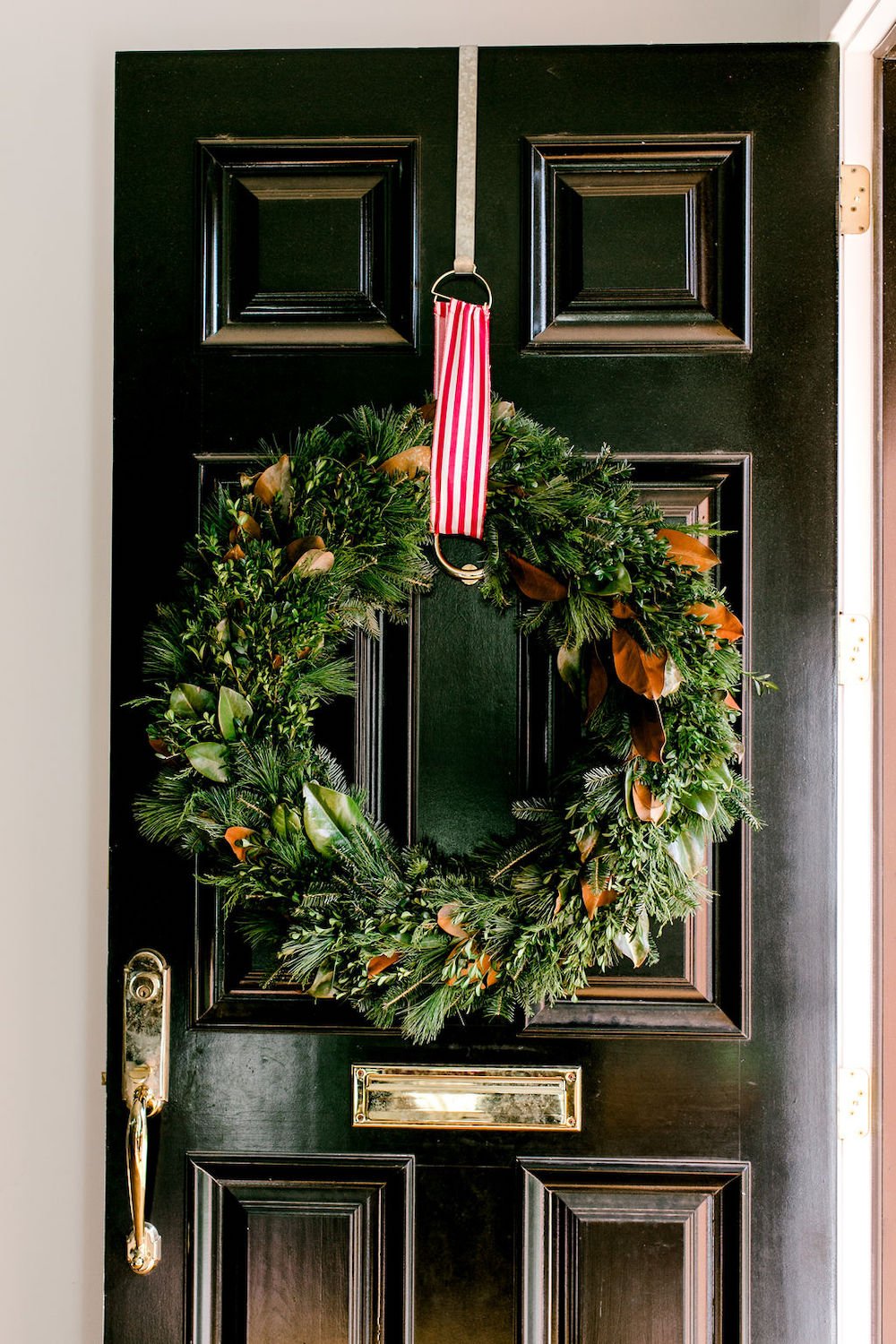 black door with a holiday wreath