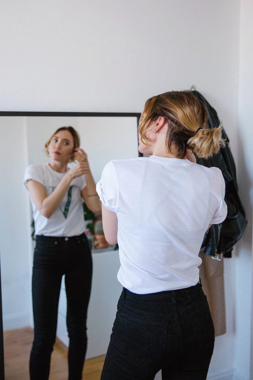 ways to let go of jealousy at work, black jeans, white tee, mirror, work chic outfit