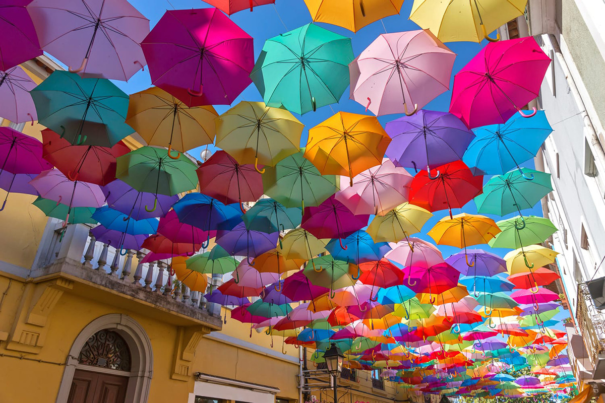 The Annual Umbrella Installation in Águeda, Portugal  AgitÁgueda, an annual art festival in Águeda, put the city on the map in 2006 with this whimsical installation. Every year in July, you'll see hundreds a canopy of floating umbrellas above the streets of the city during the festival.