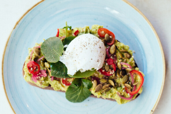 smashed avocado toast two hands NYC