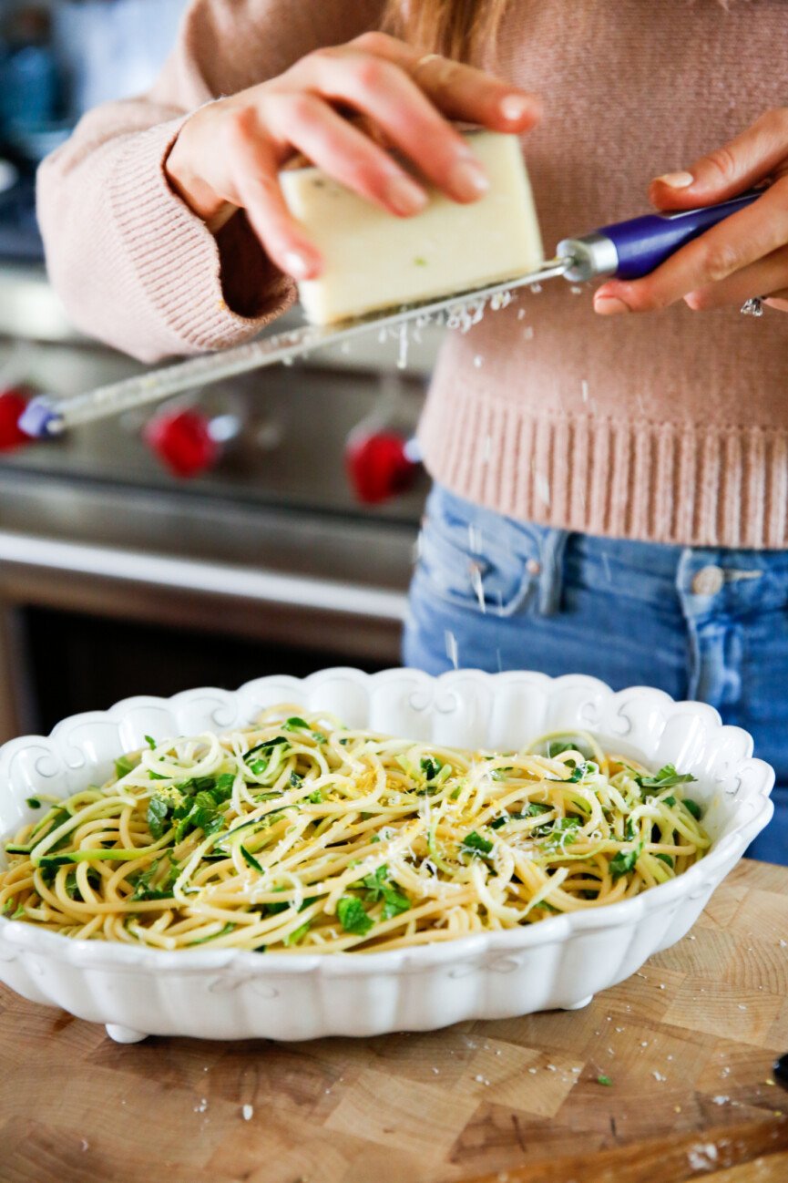 grating cheese on lemony pasta carbonara