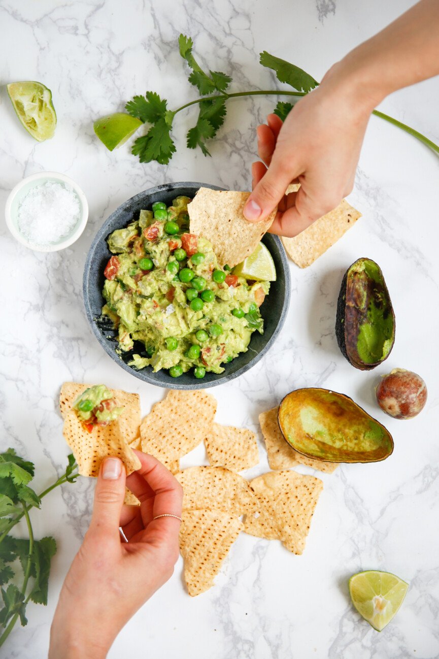 dipping chips in green pea guacamole