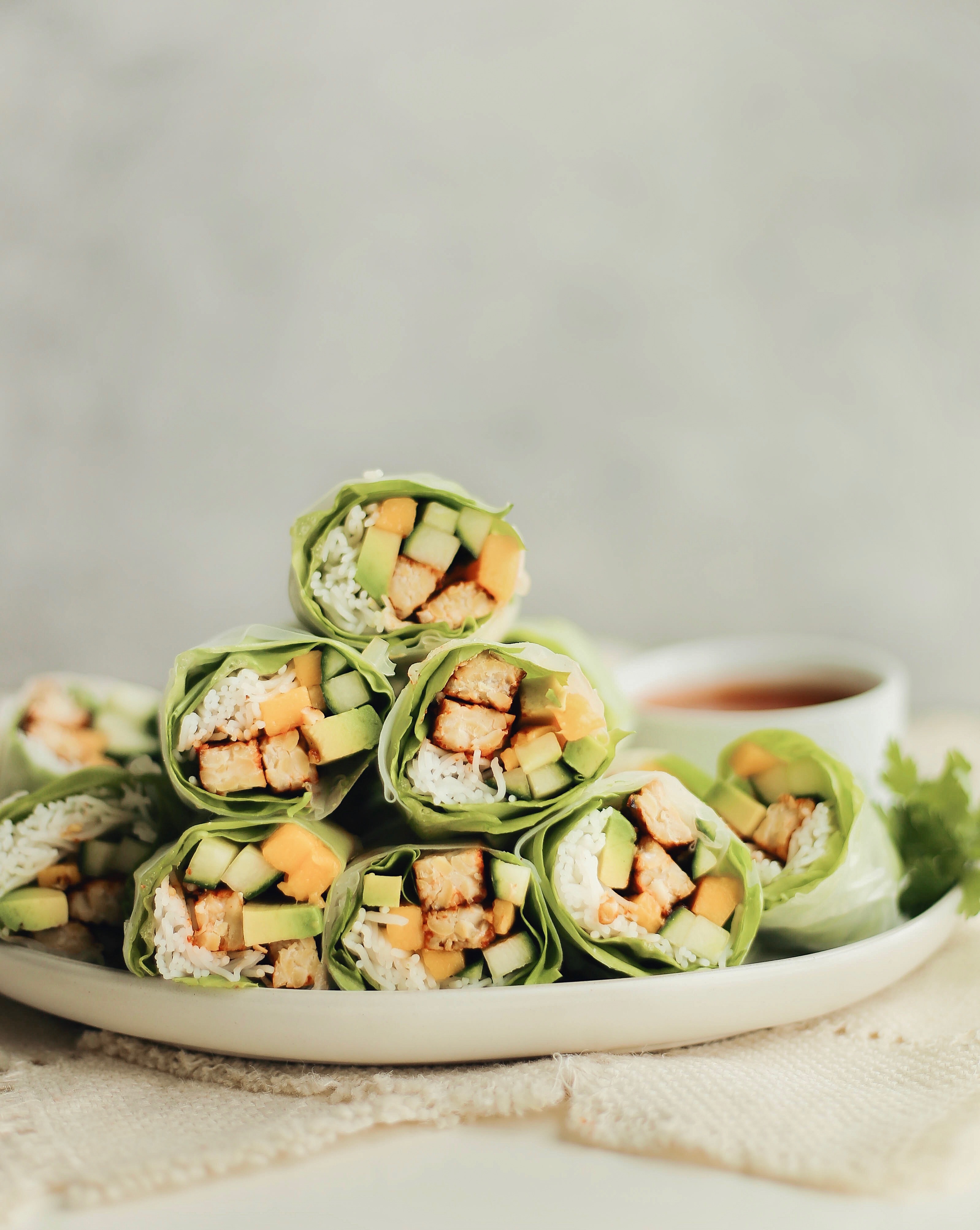 honey sriracha marinated tempeh rice noodle spring rolls with cucumber, mango, and avocado