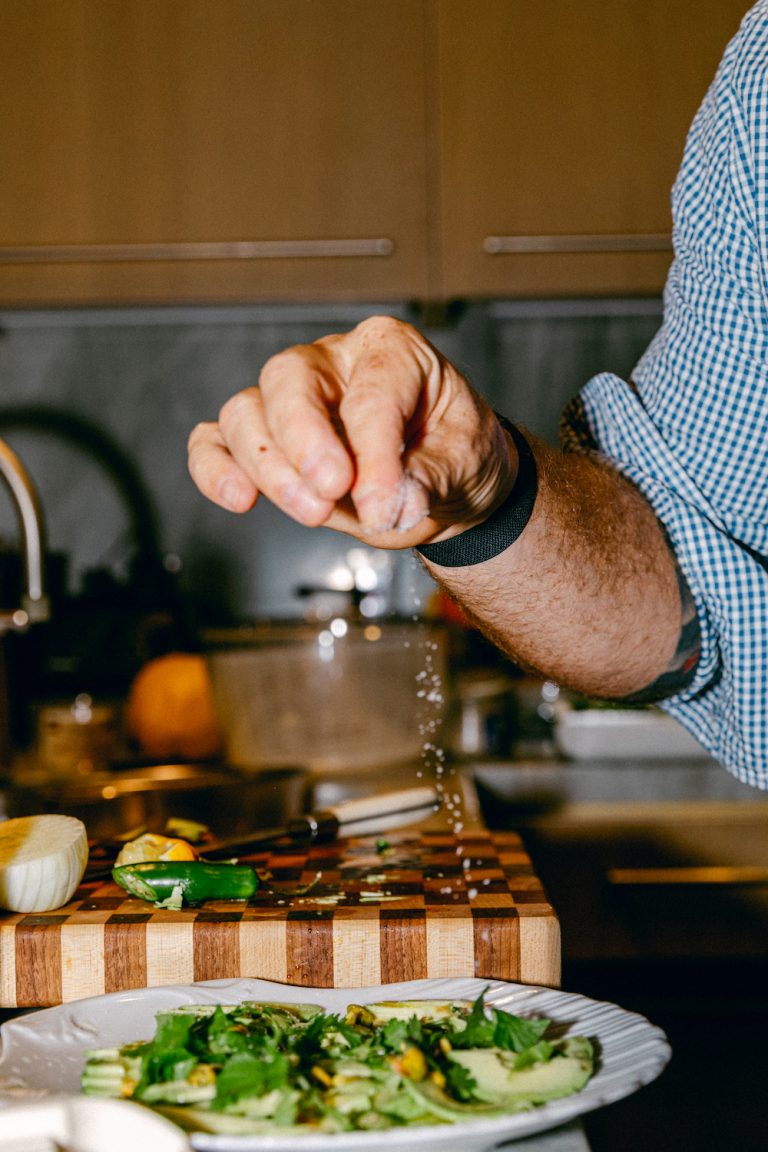 chef Seamus Mullen seasoning veggies in his kitchen