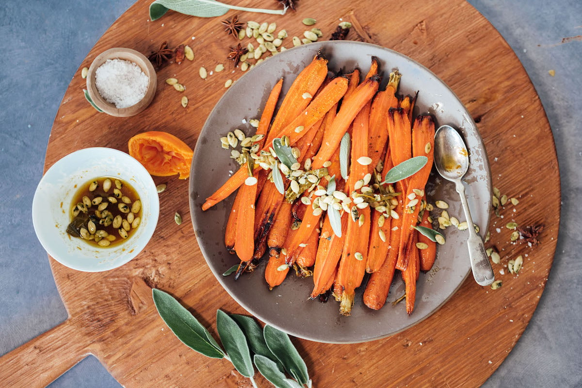 Zanahorias asadas con miel con cítricos picantes, salvia y pepitas: guarnición fácil de acción de gracias, zanahorias glaseadas con miel