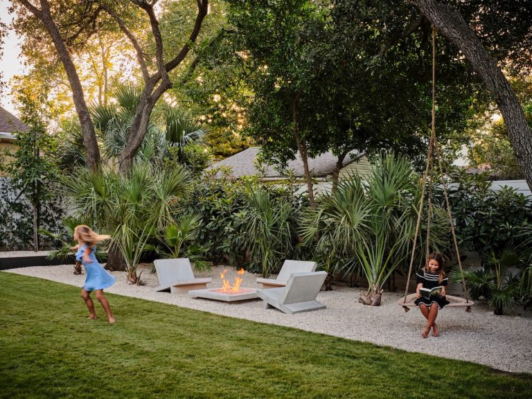 Beautiful backyard with cement chairs and modern fire pit