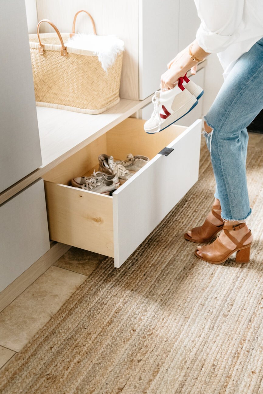 Woman stores shoes in wardrobe.