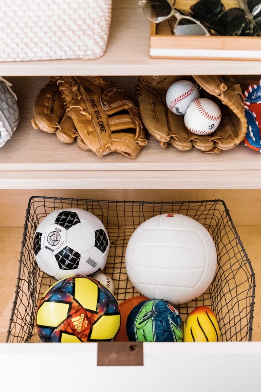 Sports equipment stored in closet.