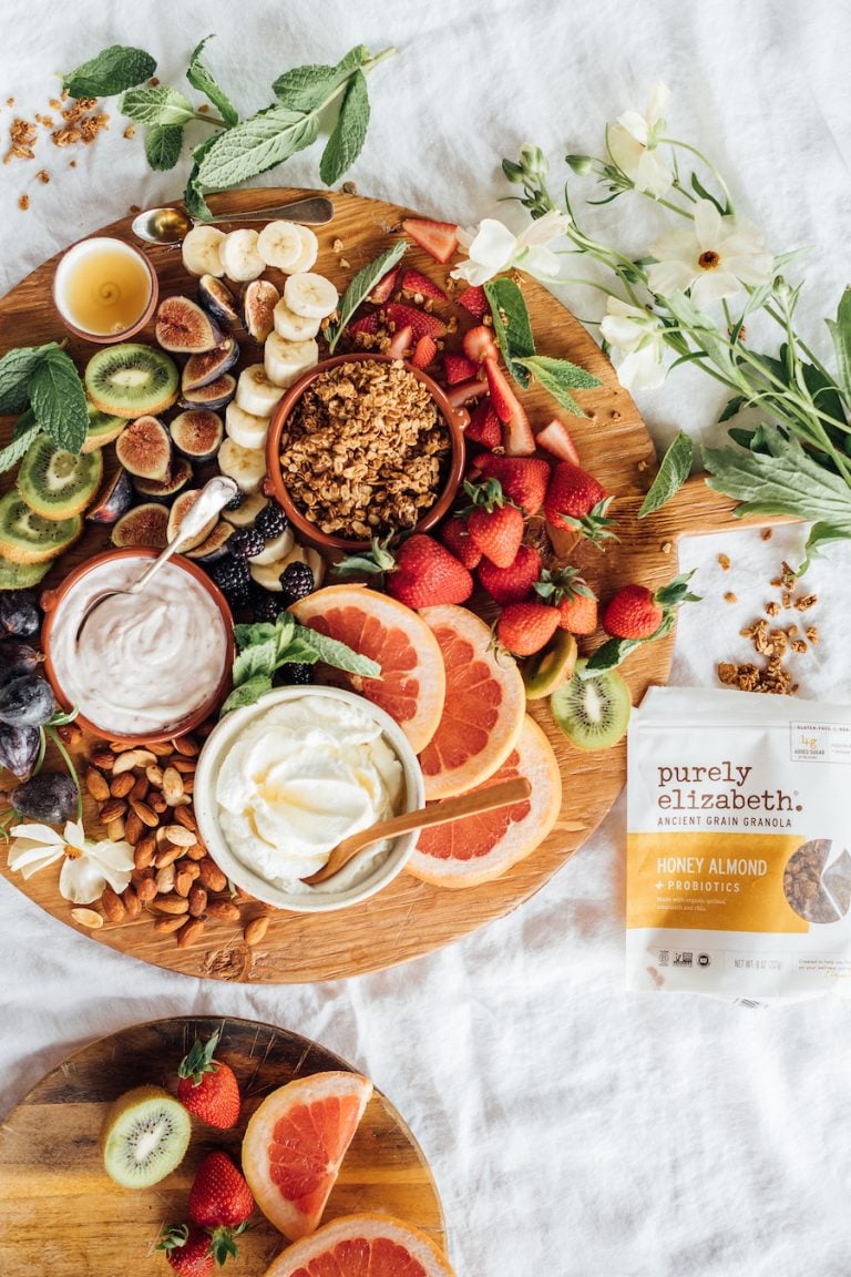 breakfast charcuterie board with fruit, yogurt, and granola