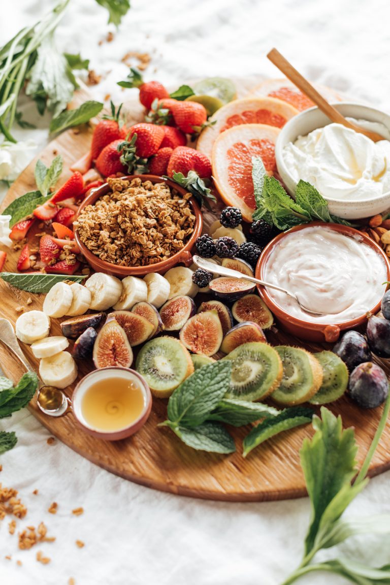 breakfast charcuterie board with fruit, yogurt, and granola