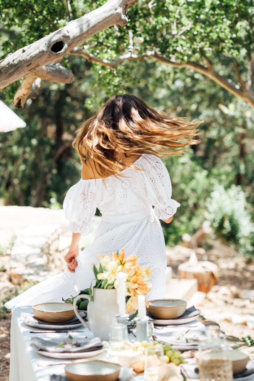 dance, celebrate, rotating summer party table ideas, Camille Styles summer dinner table in backyard with plants, white dress