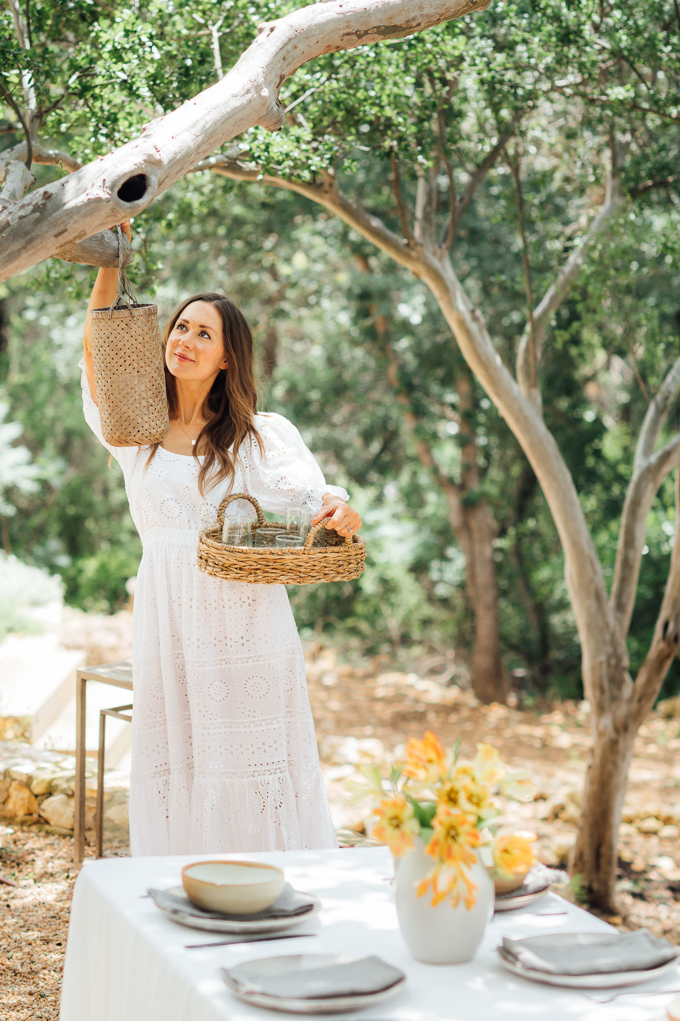 camille hanging lanterns for a backyard summer dinner party