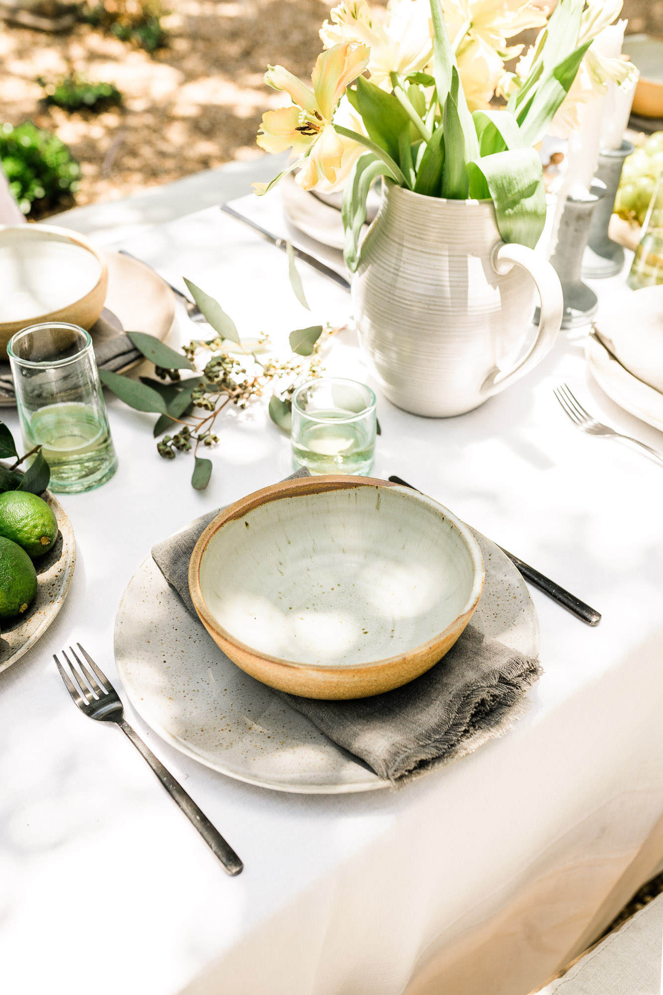rustic place setting for a backyard dinner party with ceramic plates