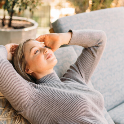 Iskra Lawrence laying outside on lounger chair in sun.