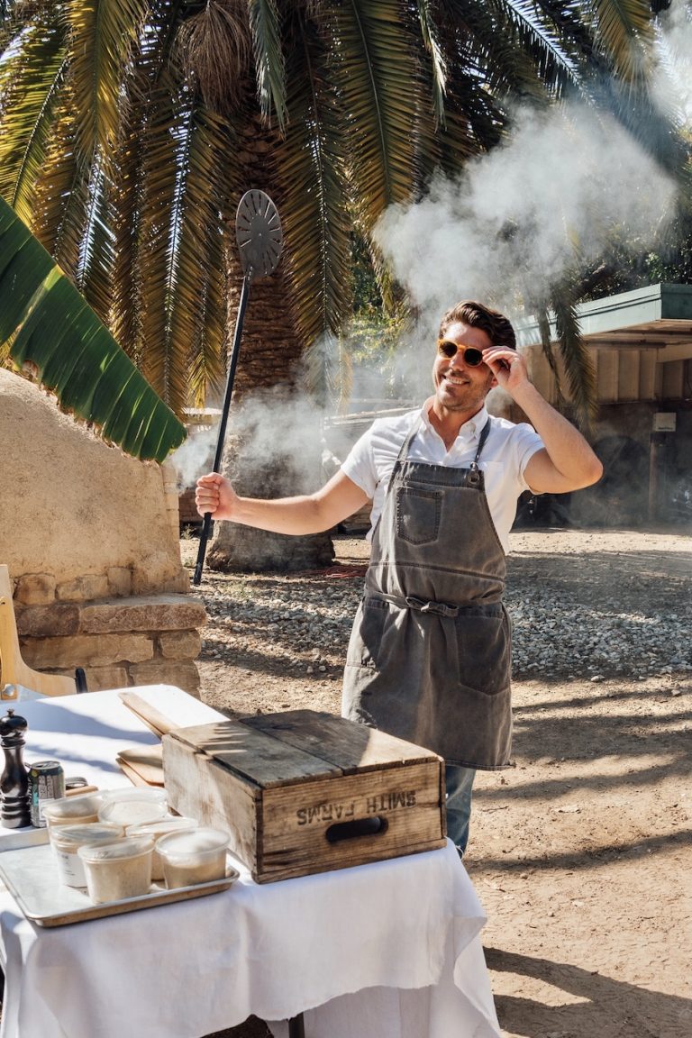 Oliver English making wood-fired pizza in an pizza oven at Plumcot Farm