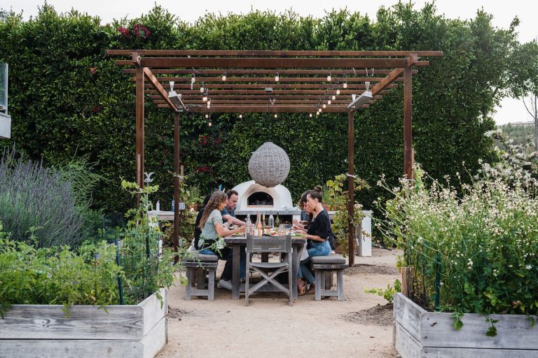 summer dinner party - beautiful backyard at sunset with covered terrace and pizza oven - helene henderson home - malibu farm