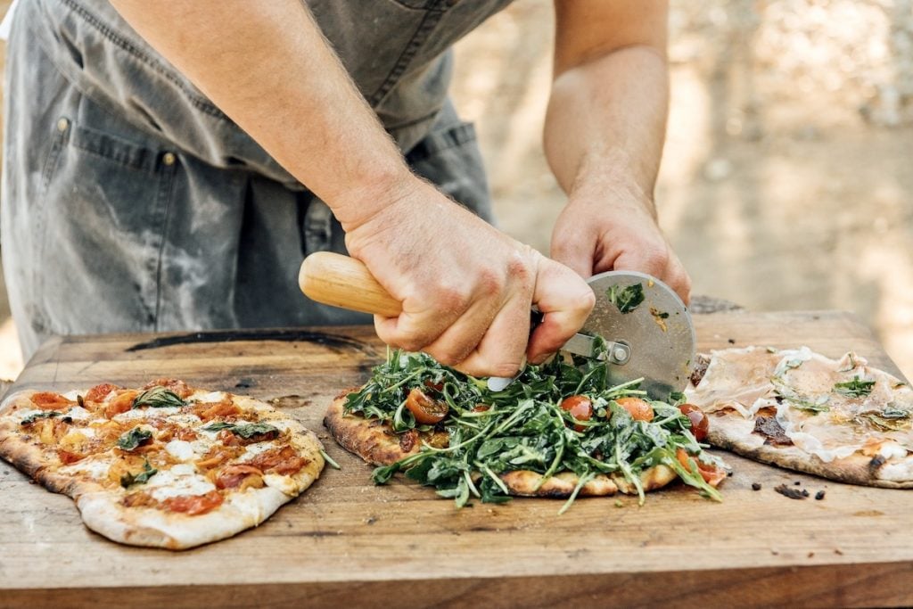 Chef Oliver English making pizza on the pizza oven at Plumcot Farm in Malibu