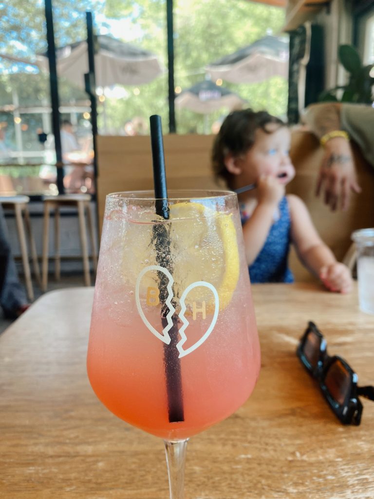 Pink spritz cocktail with straw and lemon at Better Half Coffee & Cocktails in Austin.