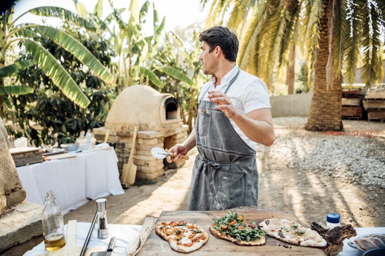 Chef Oliver English making pizza on the pizza oven at Plumcot Farm in Malibu