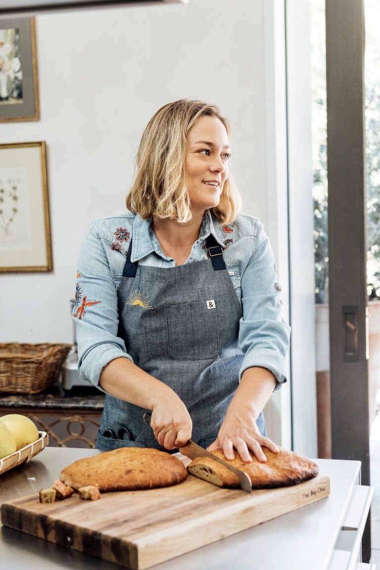 Alison Hersel cutting bread in kitchen, farmer at Plumcot Farm, Malibu