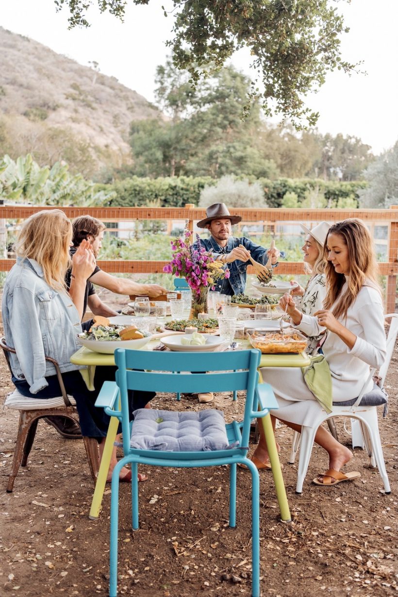Guests sit at a table during a summer dinner party at the Plumcot farm in Malibu