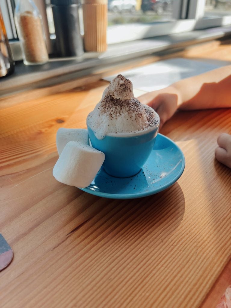 Babyccino with marshmallows in blue cup and saucer at Proud Mary in Austin.