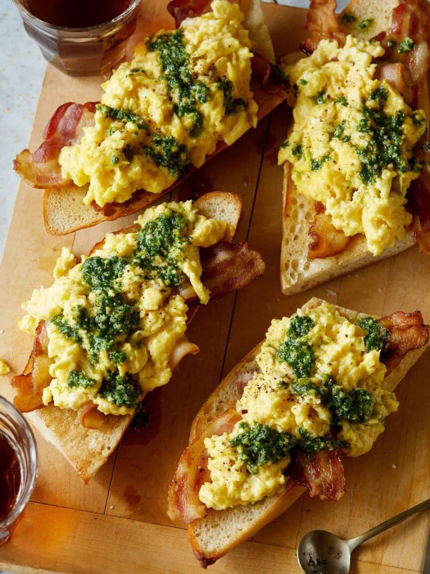 soft scrambled eggs with pesto from spoon fork bacon