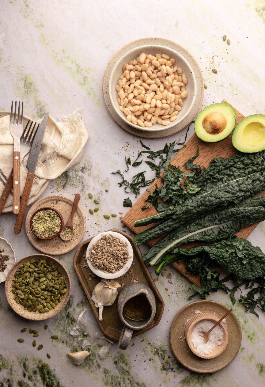 Rustic flat lay of kale, white beans, and seeds — wholesome ingredients for a healthy, balanced diet