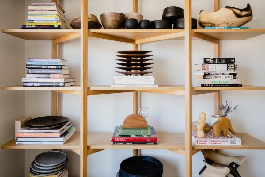 bookshelf decorated with natural materials and sculptural objects.
