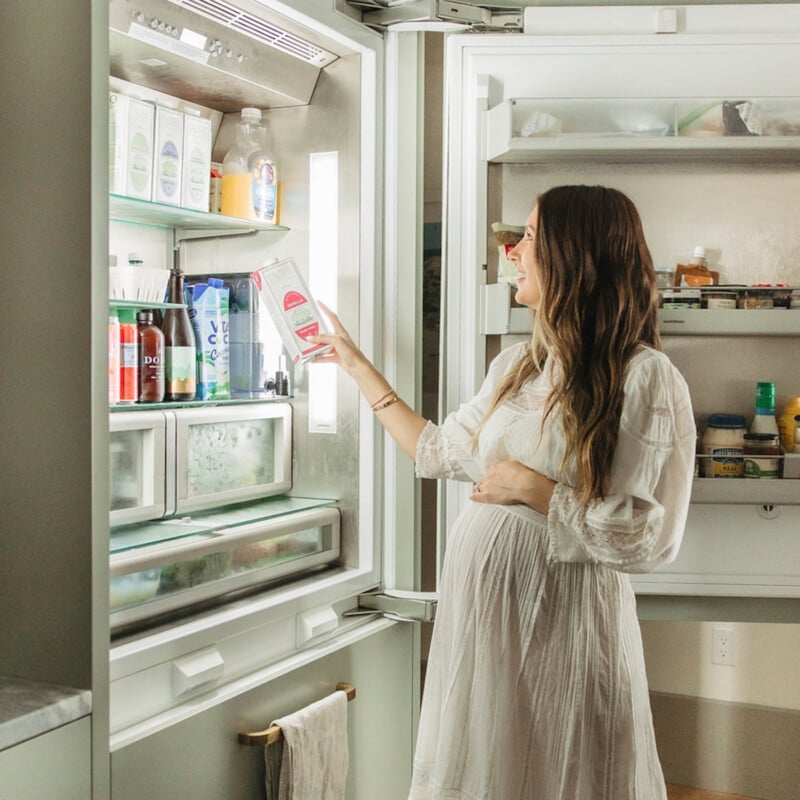 Woman reaching into fridge