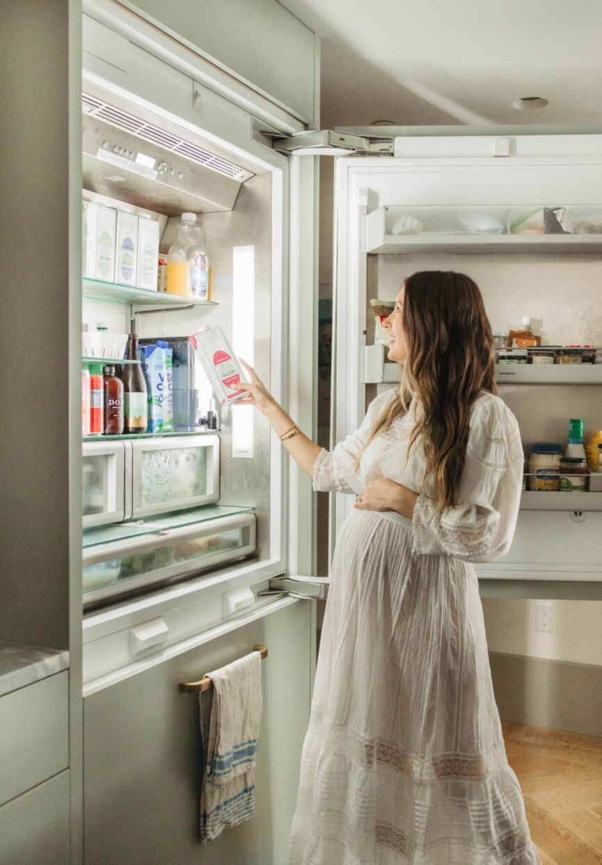 Woman reaching into fridge