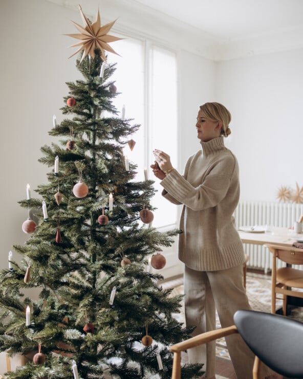 Woman decorating modern Christmas tree