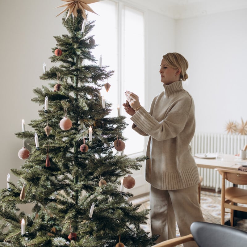 Woman decorating modern Christmas tree