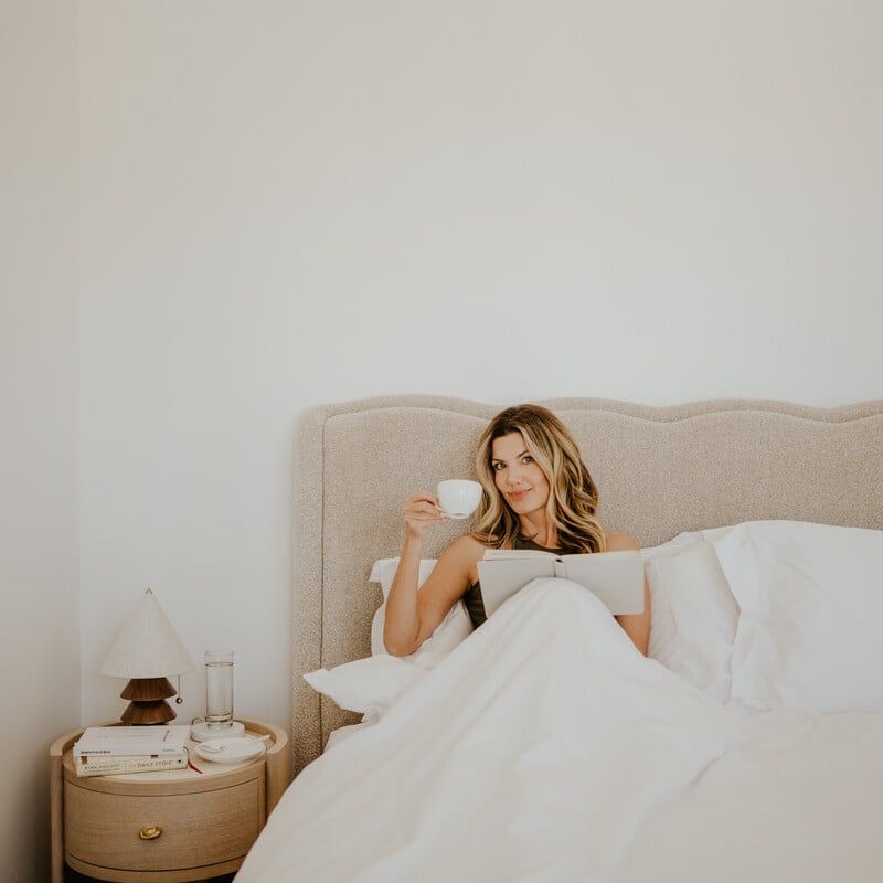 Woman drinking tea in bed_colostrum and gut health