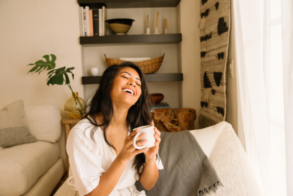 Woman smiling drinking tea_tea for menstrual cramps