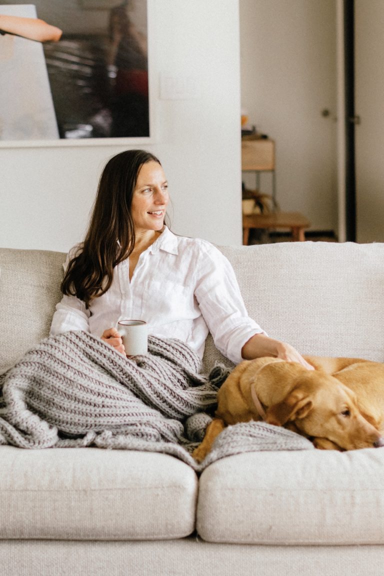 Kate Waitzkin sitting on couch with dog_postpartum essentials