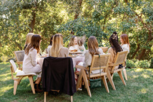 Women seated at outdoor table for Galentine's Day.