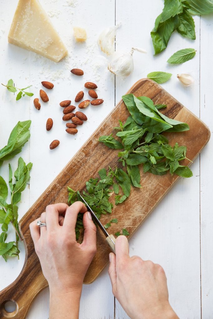 pesto, herbs, chopping, cutting board, hands_how to keep your herbs fresh in the fridge