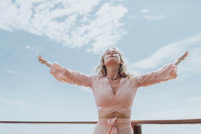 Woman with arms raised to the sky in a relaxed state