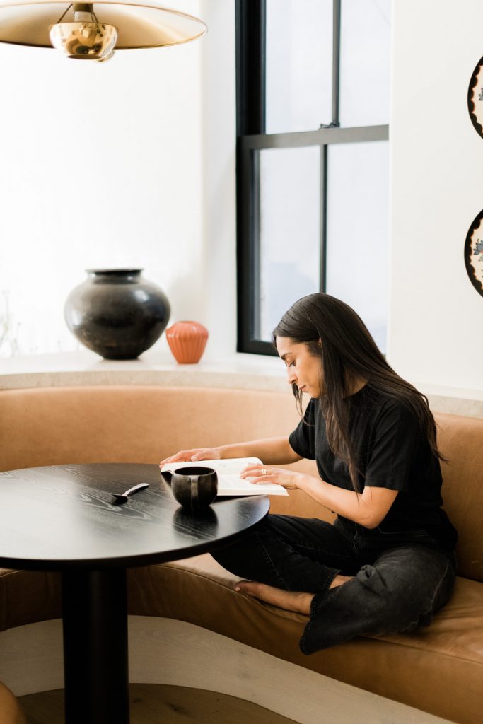 Shani Van Breukelen reading and drinking coffee at her breakfast nook_when to drink coffee