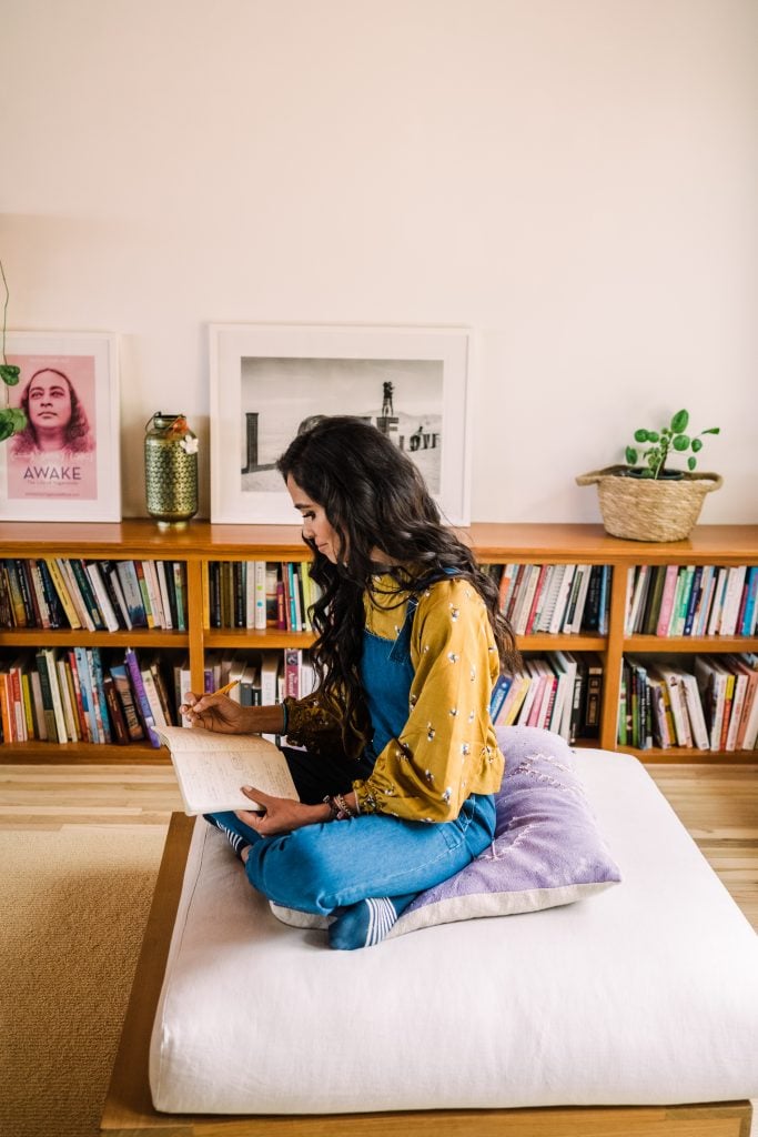 Kimberly Snyder sitting on a meditation cushion journaling_sober curious books