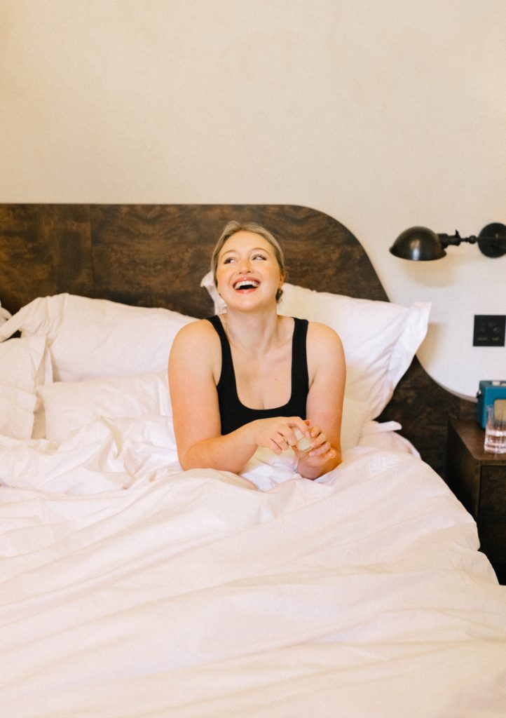 Iskra in bed going through her morning beauty routine_best affordable luxury sheets