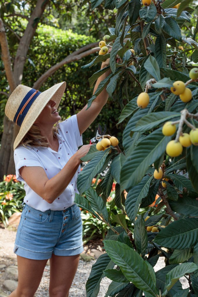 Valerie Rice picking citrus fruits in her garden