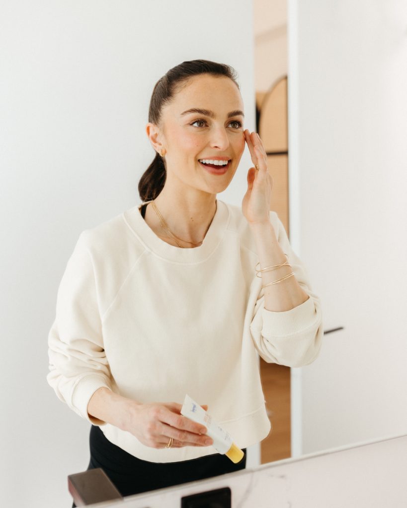 Megan Roup patting face with eye cream skincare at bathroom mirror_Best Skincare for Your 30s